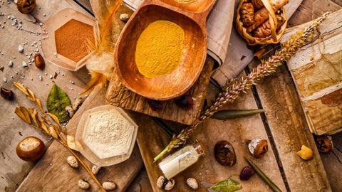 Bols en bois remplis de poudre ocre et racines sechees, ambiance des ingredients andins du Perou, terre de la maca